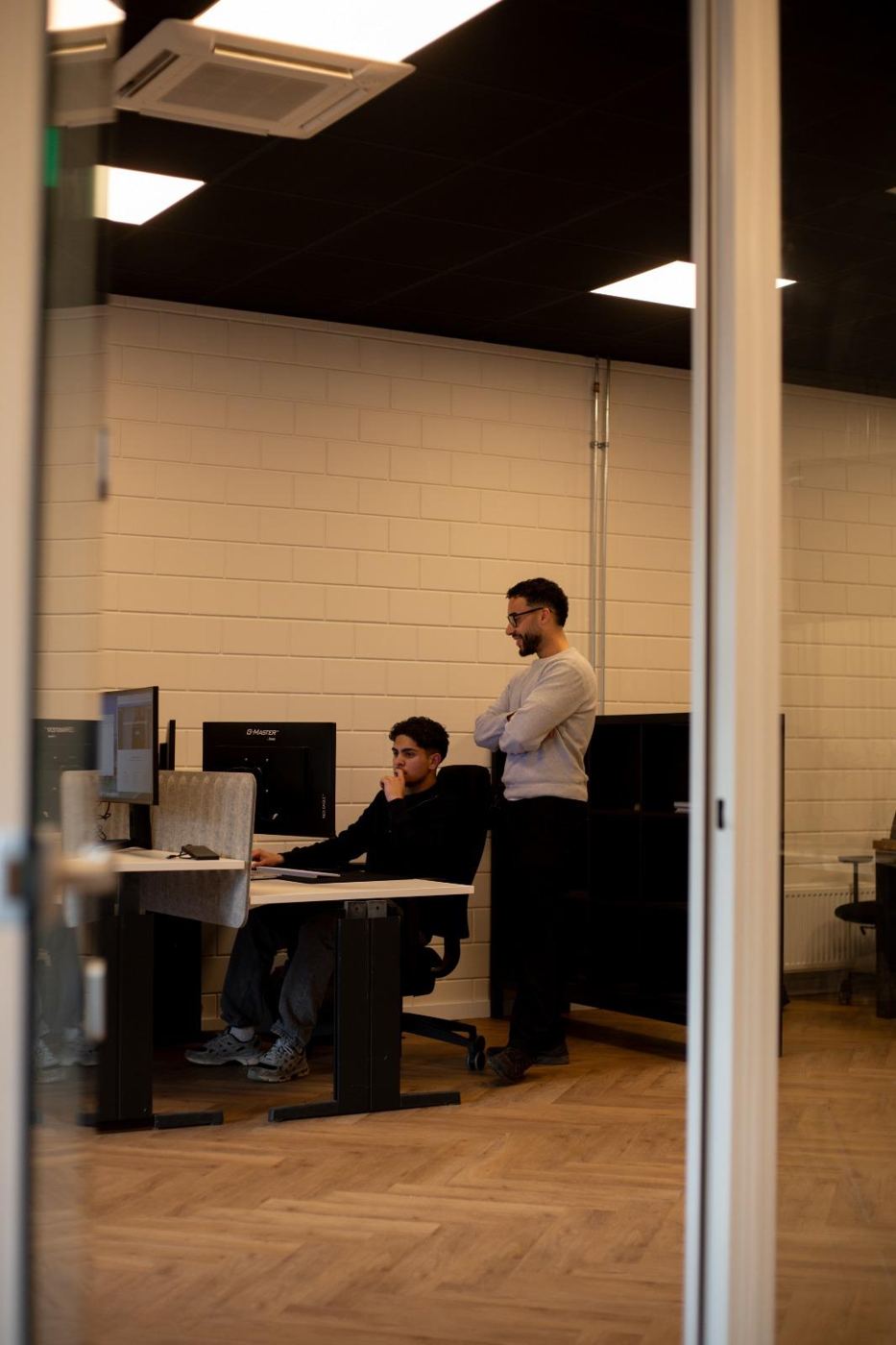 Twee collega's overleggen aan een bureau op kantoor